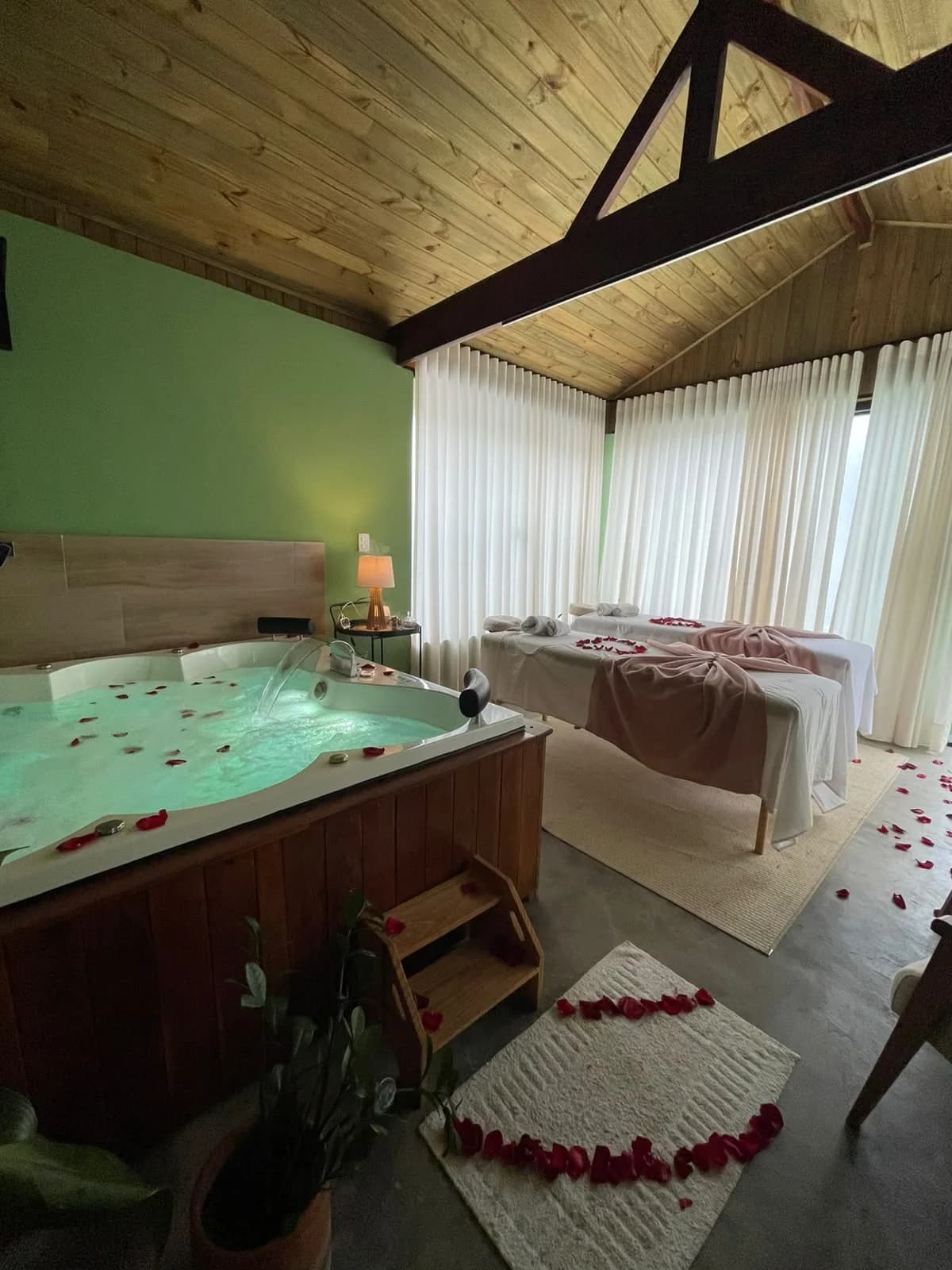 Sala privativa com jacuzzi e duas macas de massagem preparadas para casal